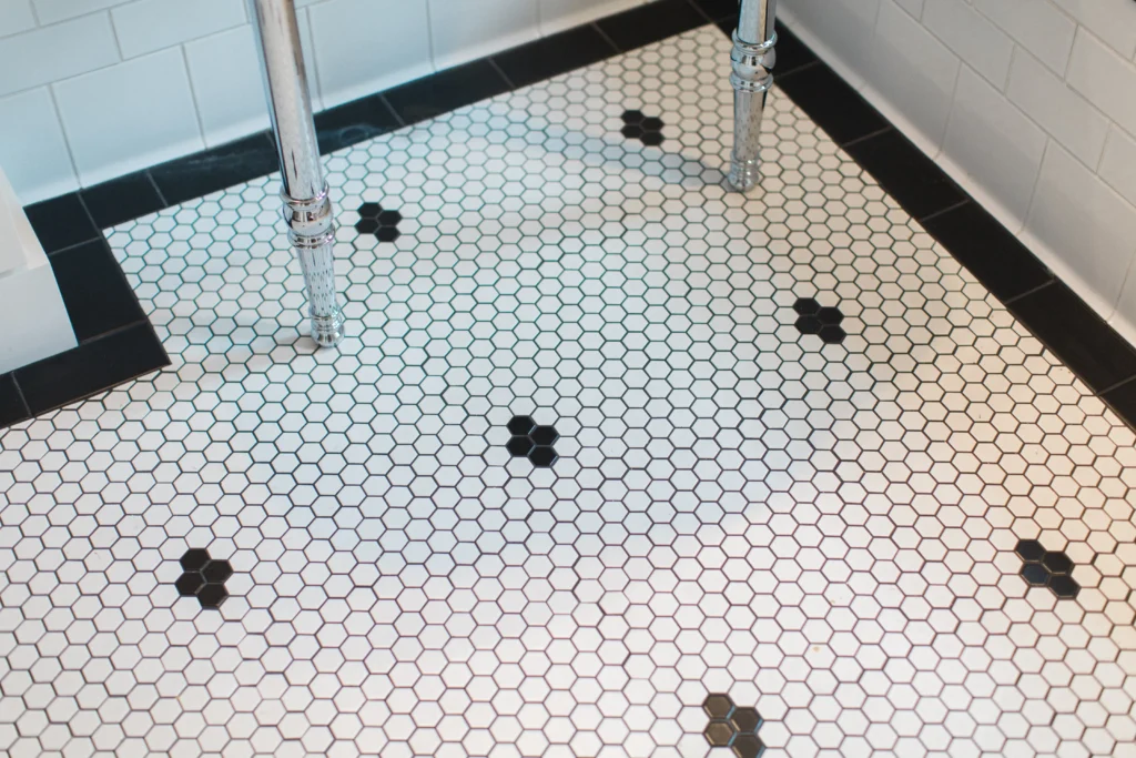 Elegant hexagonal tiles with black accents create a timeless bathroom floor design.