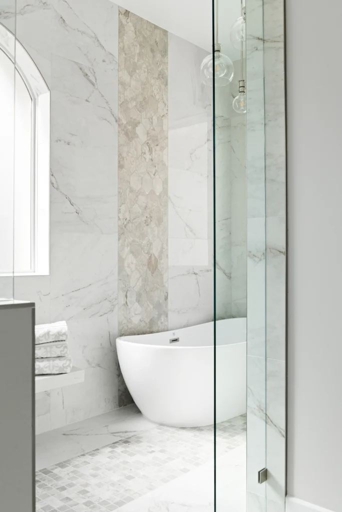 Elegant bathroom design featuring marble tiles, freestanding tub, and minimalist decor for ultimate relaxation.