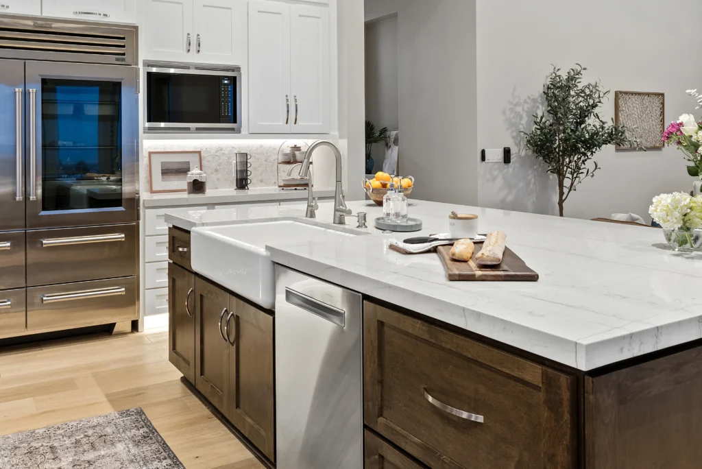 Modern kitchen with marble island, dark cabinetry, and abundant natural light for inviting gatherings.