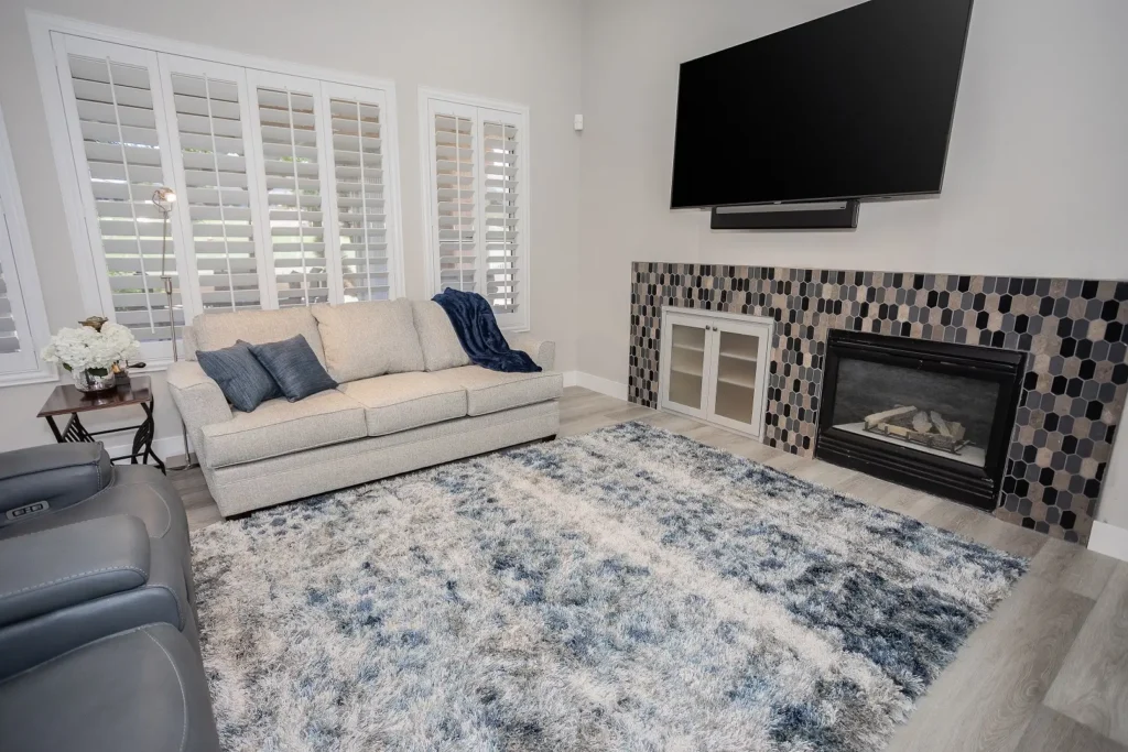 Modern family room with elegant fireplace, light gray decor, and inviting seating for relaxation.