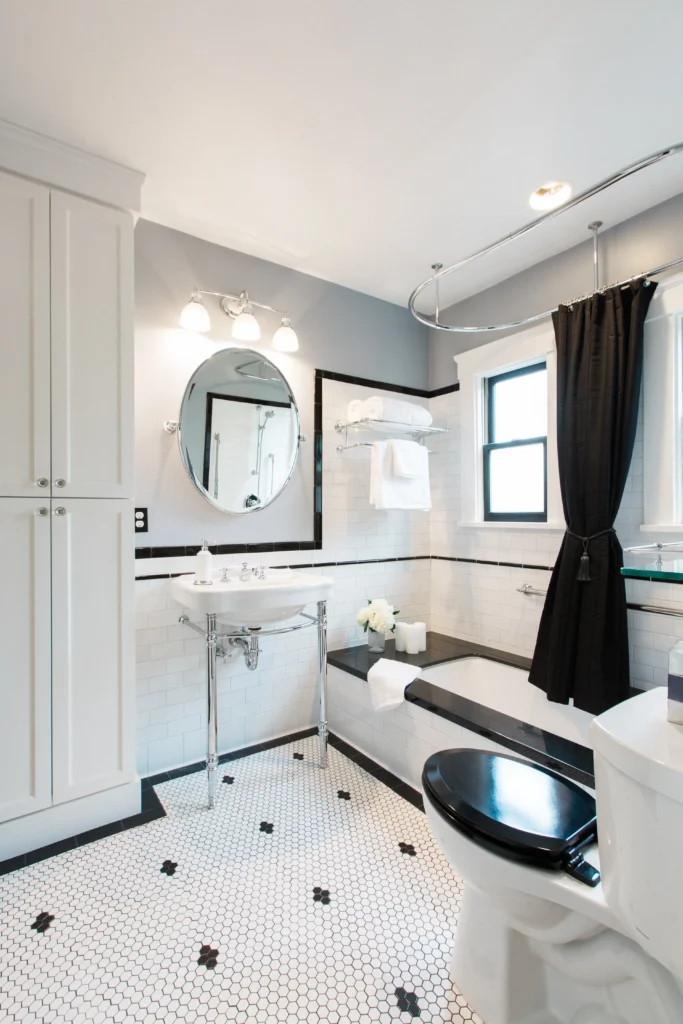 Stylish modern bathroom with chic black and white accents, a sleek vanity, and freestanding tub.