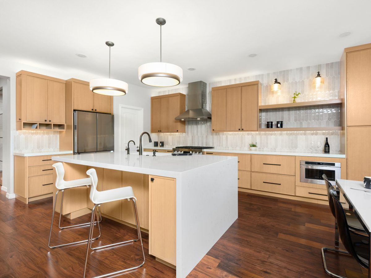 Warm oak shaker kitchen with quartz island, picket tile backsplash, and dark bronze fixtures, Reveal Interior Design Las Vegas
