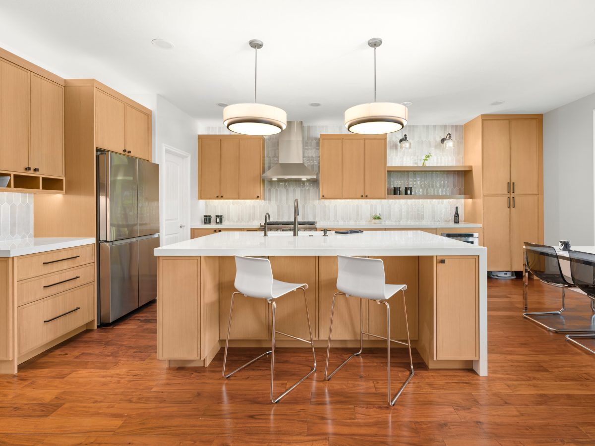 Warm oak slim shaker kitchen with quartz island, handmade-style picket backsplash tile, and dark bronze fixtures, Reveal Interior Design Las Vegas