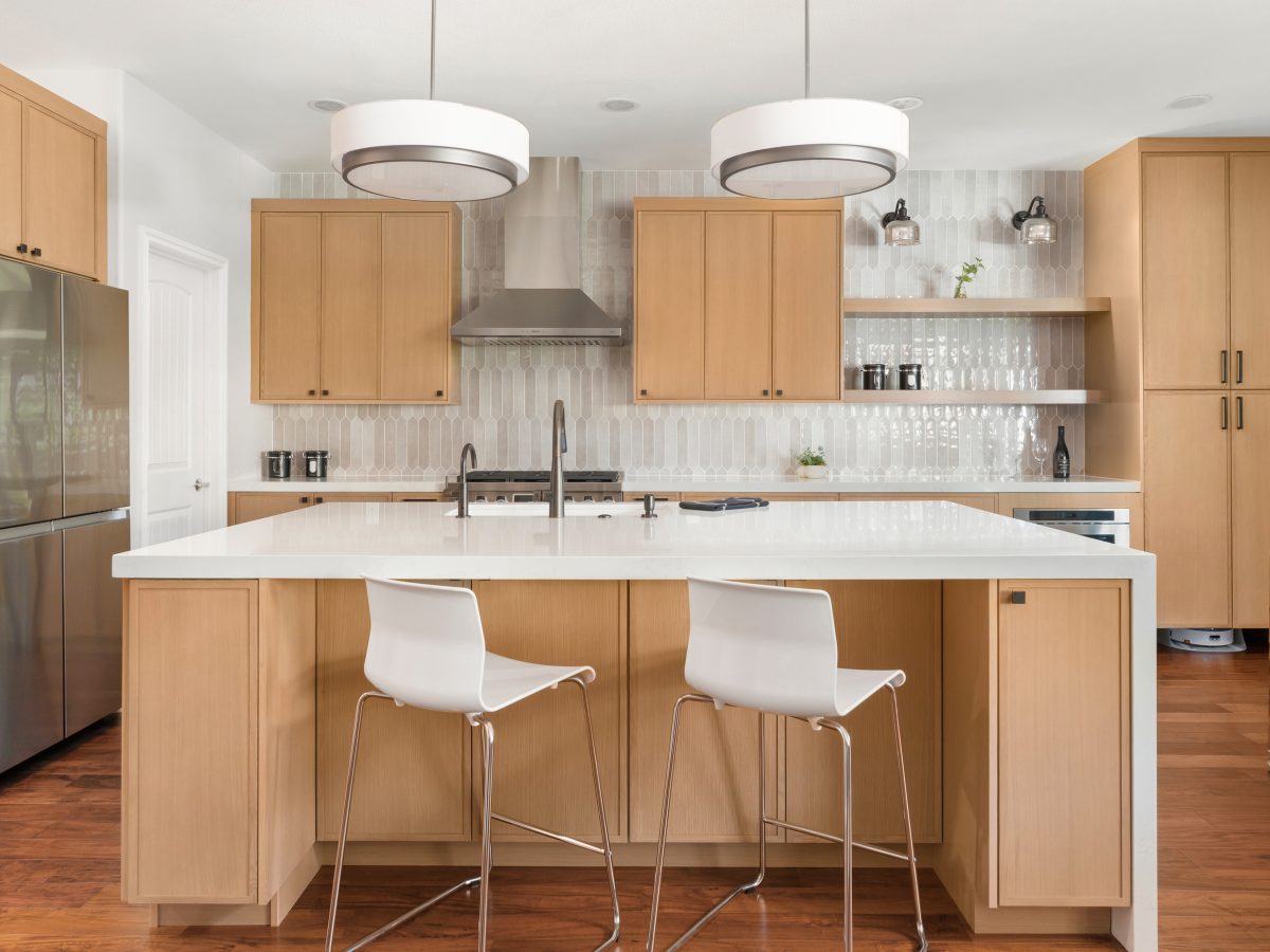 Contemporary kitchen with warm stained oak slim shaker cabinetry and off-white quartz island, Reveal Interior Design Las Vegas