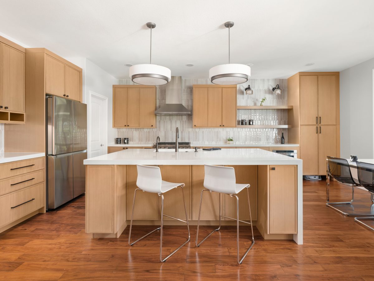 Warm oak slim shaker kitchen with quartz island, handmade-style picket backsplash tile, Reveal Interior Design Las Vegas