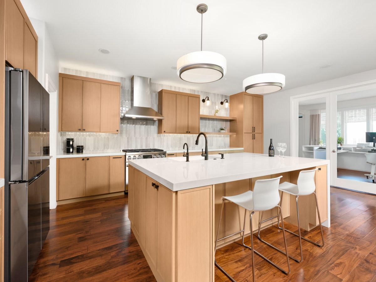 Warm oak shaker kitchen with quartz island, handmade-style picket backsplash tile, and dark bronze fixtures, Reveal Interior Design Las Vegas