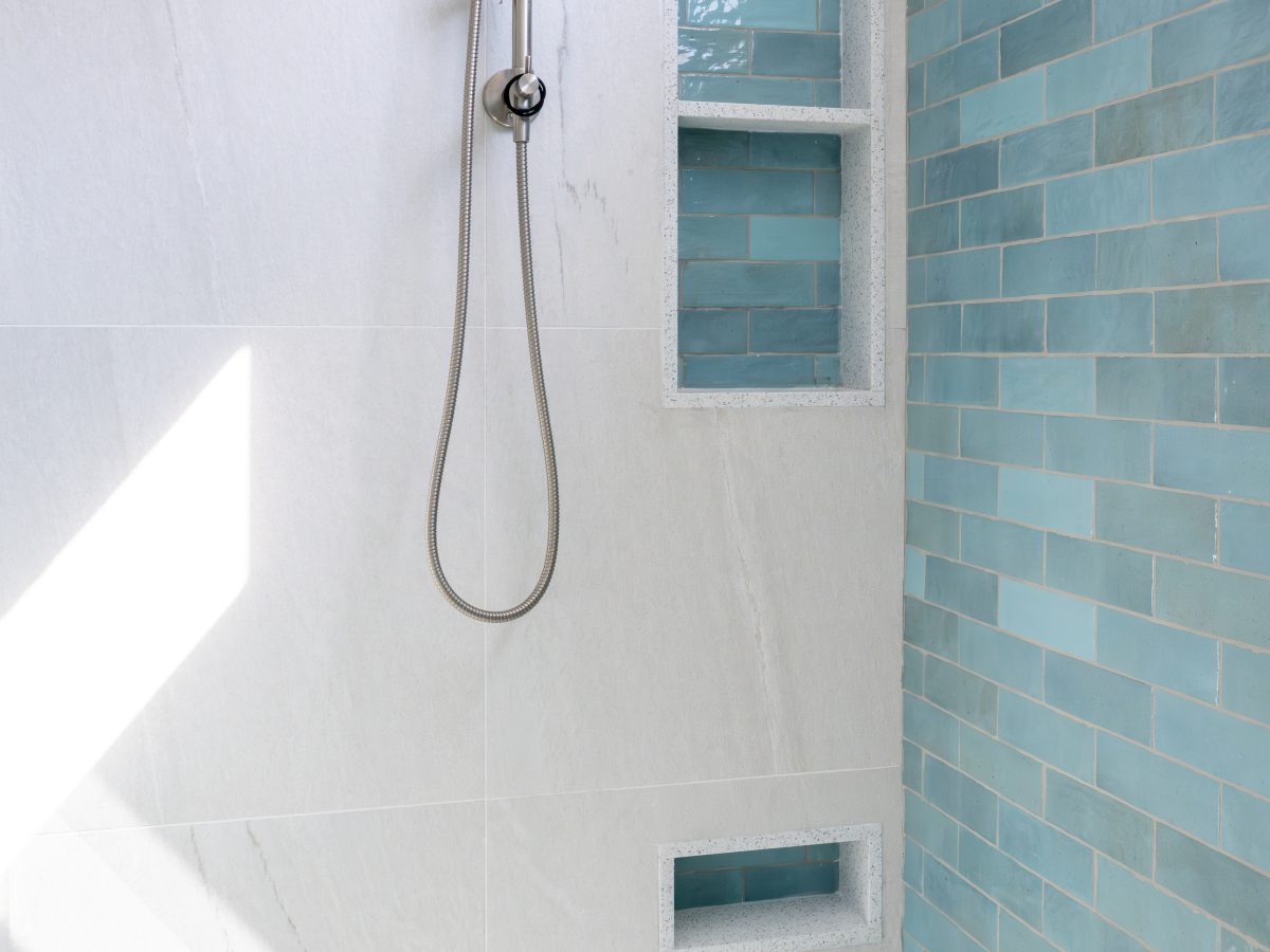 Spa primary shower with handmade teal subway tile, brushed nickel fixtures, and built-in niches, Reveal Interior Design Las Vegas
