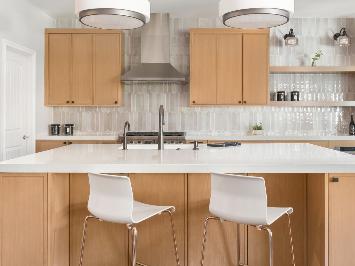 Contemporary kitchen with warm oak cabinetry and quartz island, Reveal Interior Design Las Vegas