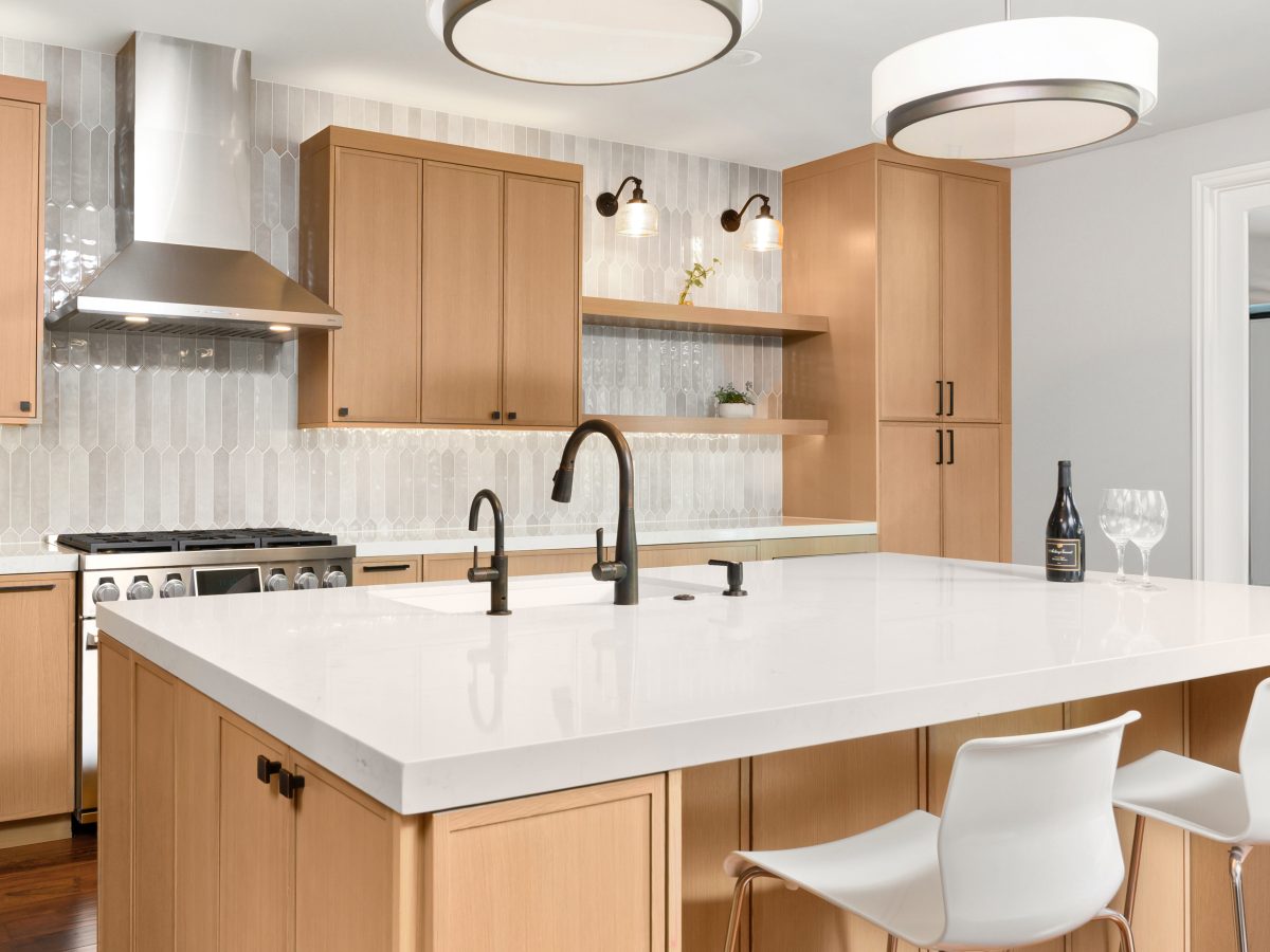 Warm oak slim shaker kitchen with quartz island, dark bronze fixtures, and handmade-look picket backsplash tile, Reveal Interior Design Las Vegas