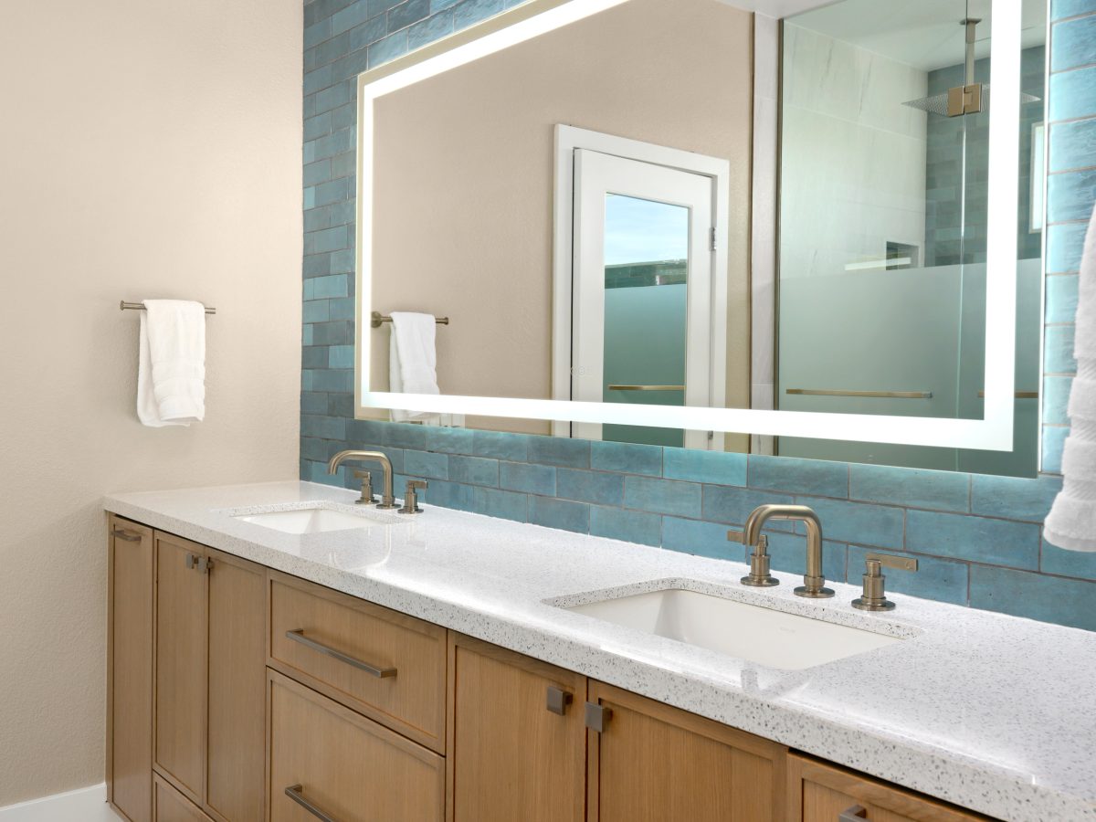 Primary bathroom double vanity with white quartz countertops and handmade teal subway tile backsplash, Reveal Interior Design Las Vegas