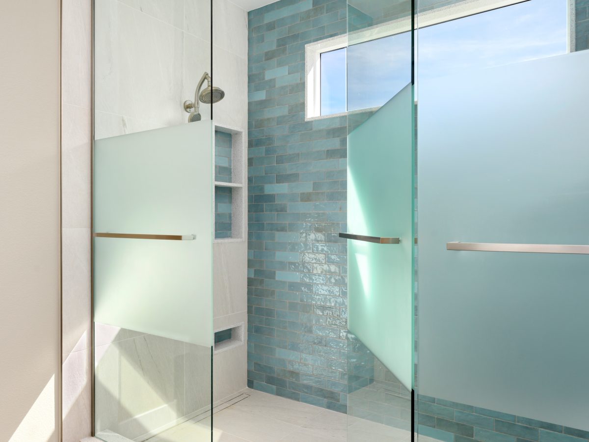 Spa-inspired two-person walk-in shower with handmade teal subway tile and custom privacy glass, Reveal Interior Design Las Vegas