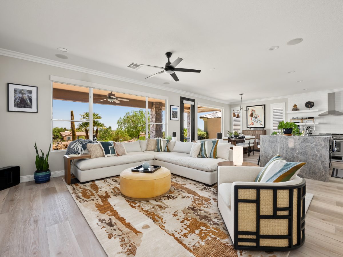 Desert Modern living room with oatmeal sectional, butterscotch leather ottoman, and warm walnut accents, Reveal Interior Design Las Vegas
