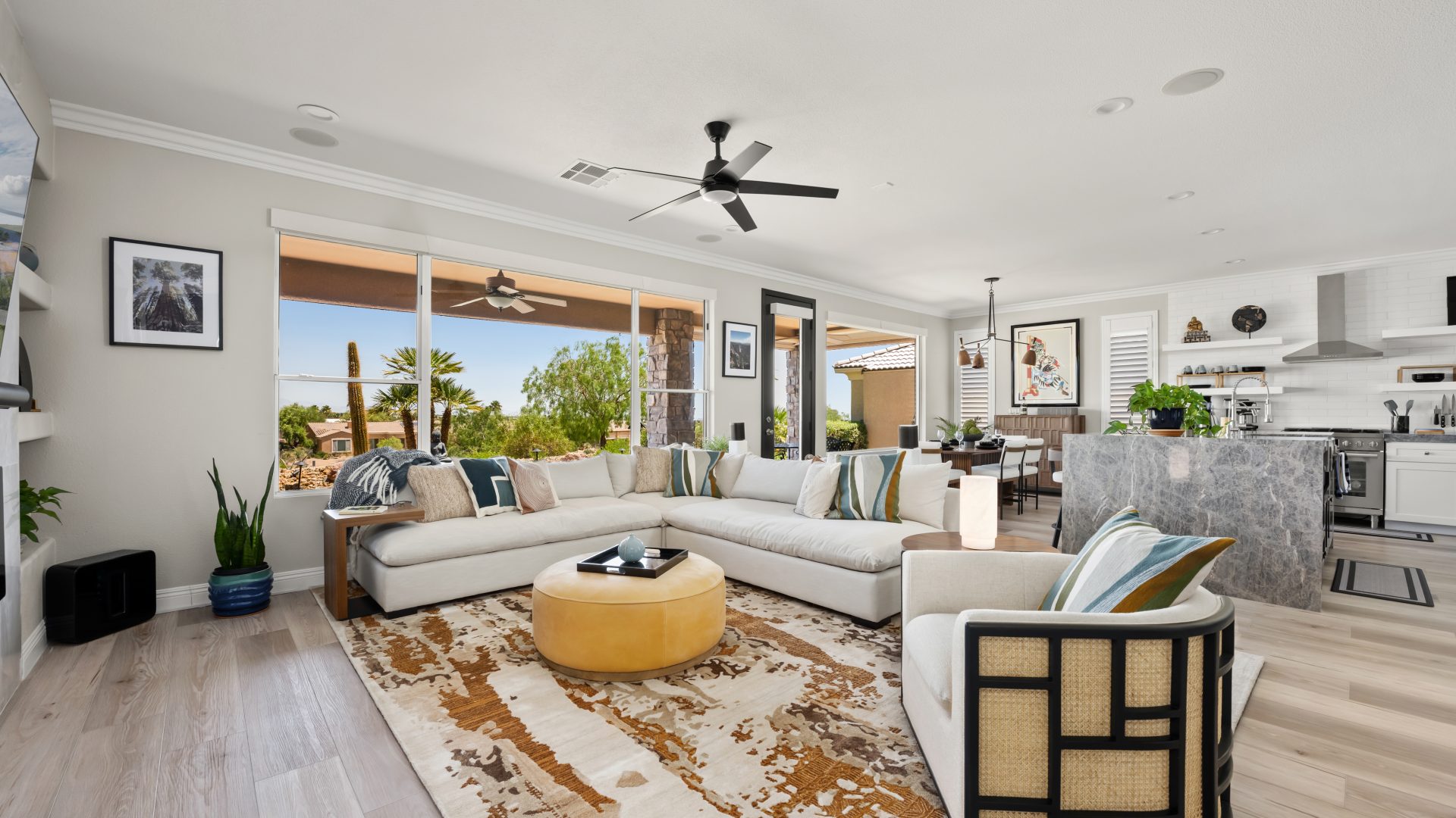 Desert Modern living room with oatmeal sectional, butterscotch leather ottoman, and warm walnut accents, Reveal Interior Design Las Vegas