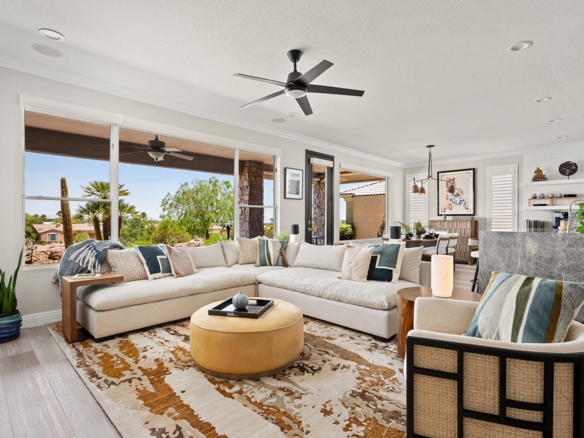 Desert Modern living room with oatmeal sectional, butterscotch leather ottoman, and warm walnut accents, Reveal Interior Design Las Vegas