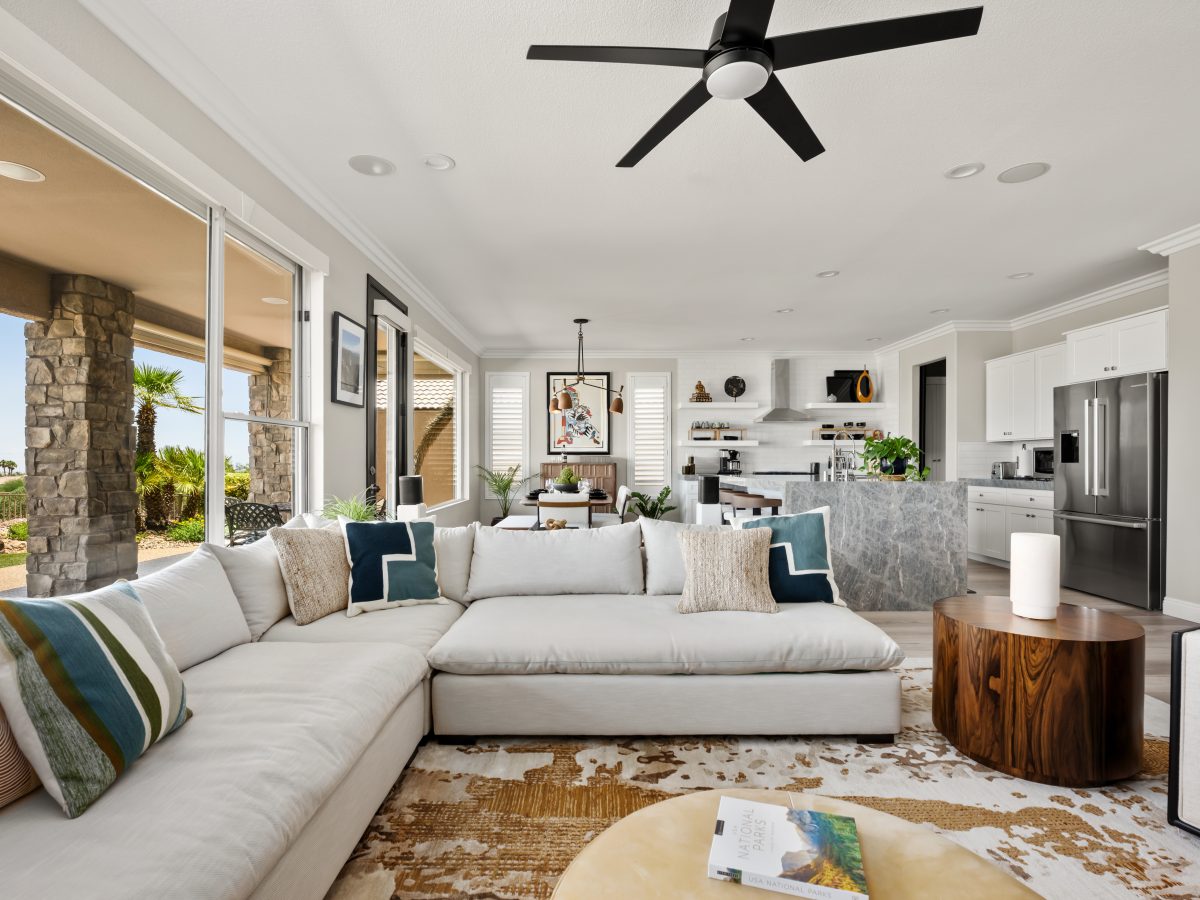 Open-concept living room with oversized oatmeal sectional and warm walnut accents, Reveal Interior Design Las Vegas