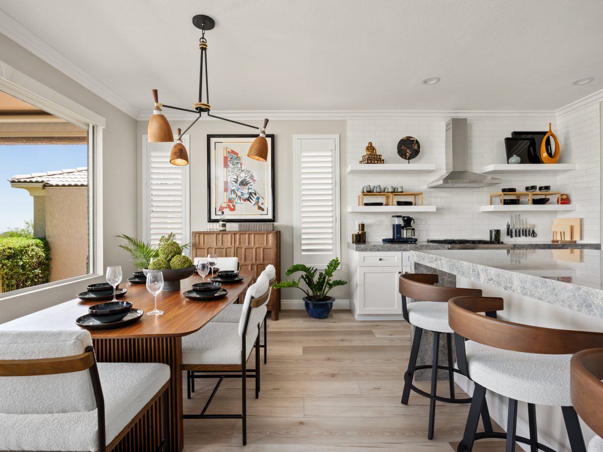 Open-concept kitchen and dining with walnut accents, white open shelving, and bold décor, Reveal Interior Design Las Vegas