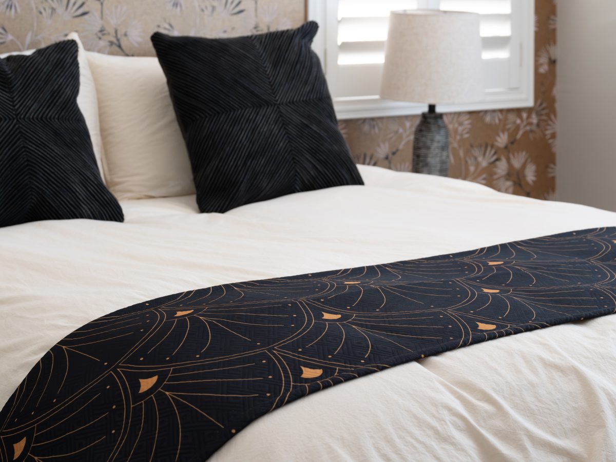 Primary bedroom with gold metallic Japanese-inspired wallpaper, walnut bed frame, and black satin runner, Reveal Interior Design Las Vegas