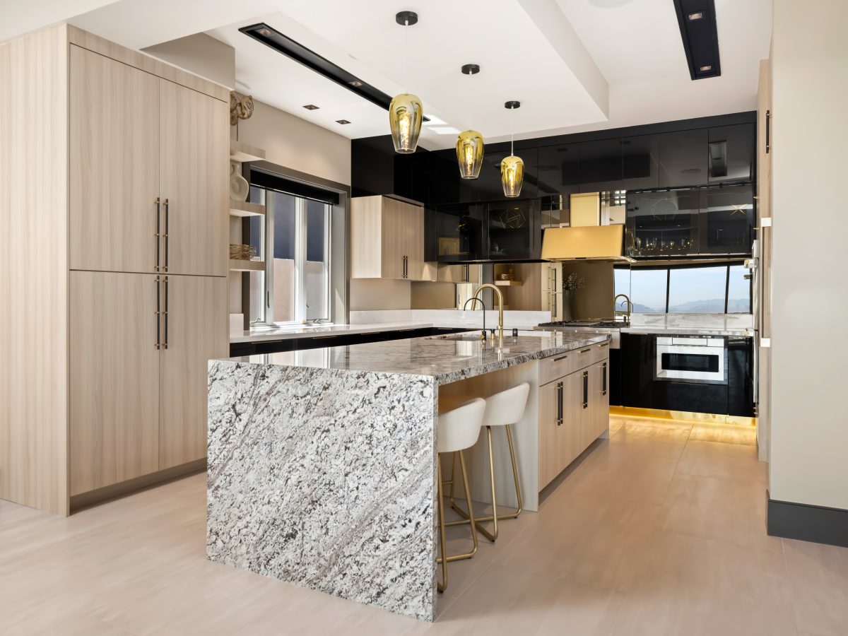 Luxury kitchen with granite waterfall island, white oak cabinetry, and mirrored backsplash, Reveal Interior Design Las Vegas