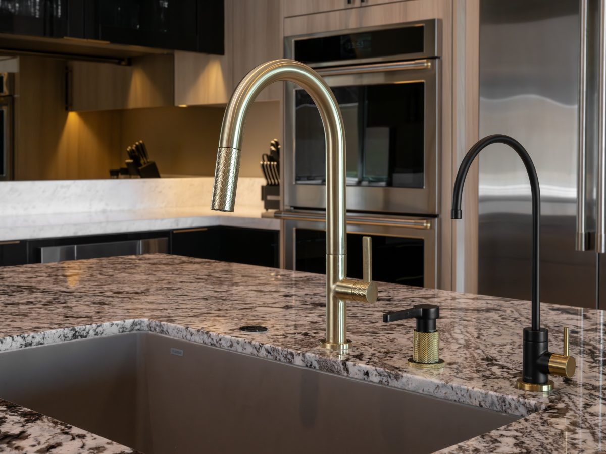 Luxury kitchen island with granite countertop, gold and black plumbing fixtures, Reveal Interior Design Las Vegas