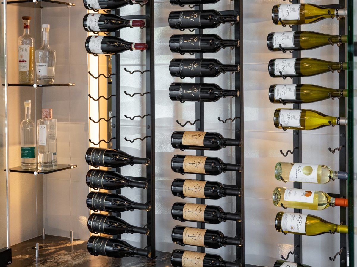 Custom wine niche with modern metal shelving, mirrored panels, and hidden LED lighting, Reveal Interior Design Las Vegas