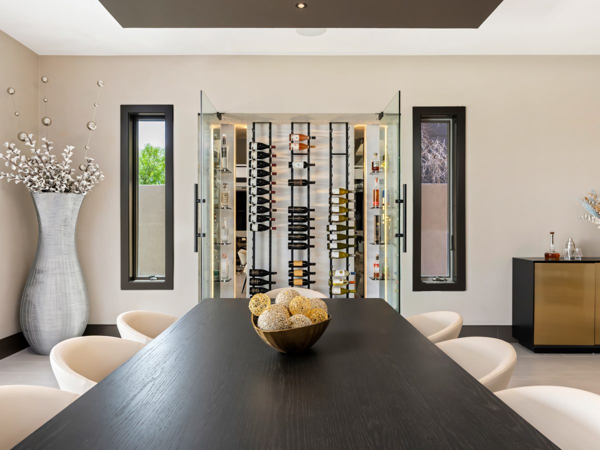 Custom wine niche with modern metal shelving, mirrored panels, and hidden LED lighting, Reveal Interior Design Las Vegas