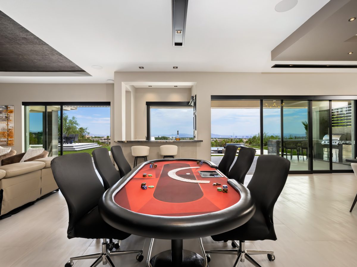 Game room with crimson felt card table and panoramic views, Reveal Interior Design Las Vegas