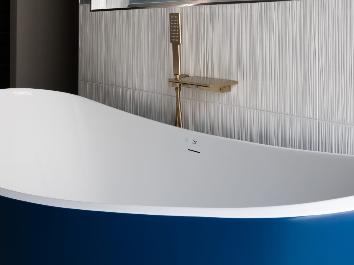 Primary bathroom with cobalt blue freestanding tub, gold fixtures, and white textured porcelain tile, Reveal Interior Design Las Vegas