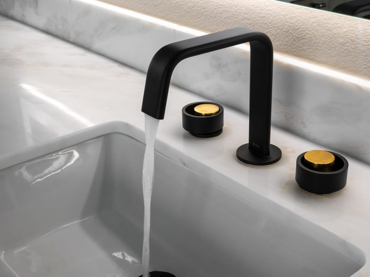 Primary bathroom black matte faucet with gold knob handles on white stone countertop, Reveal Interior Design Las Vegas