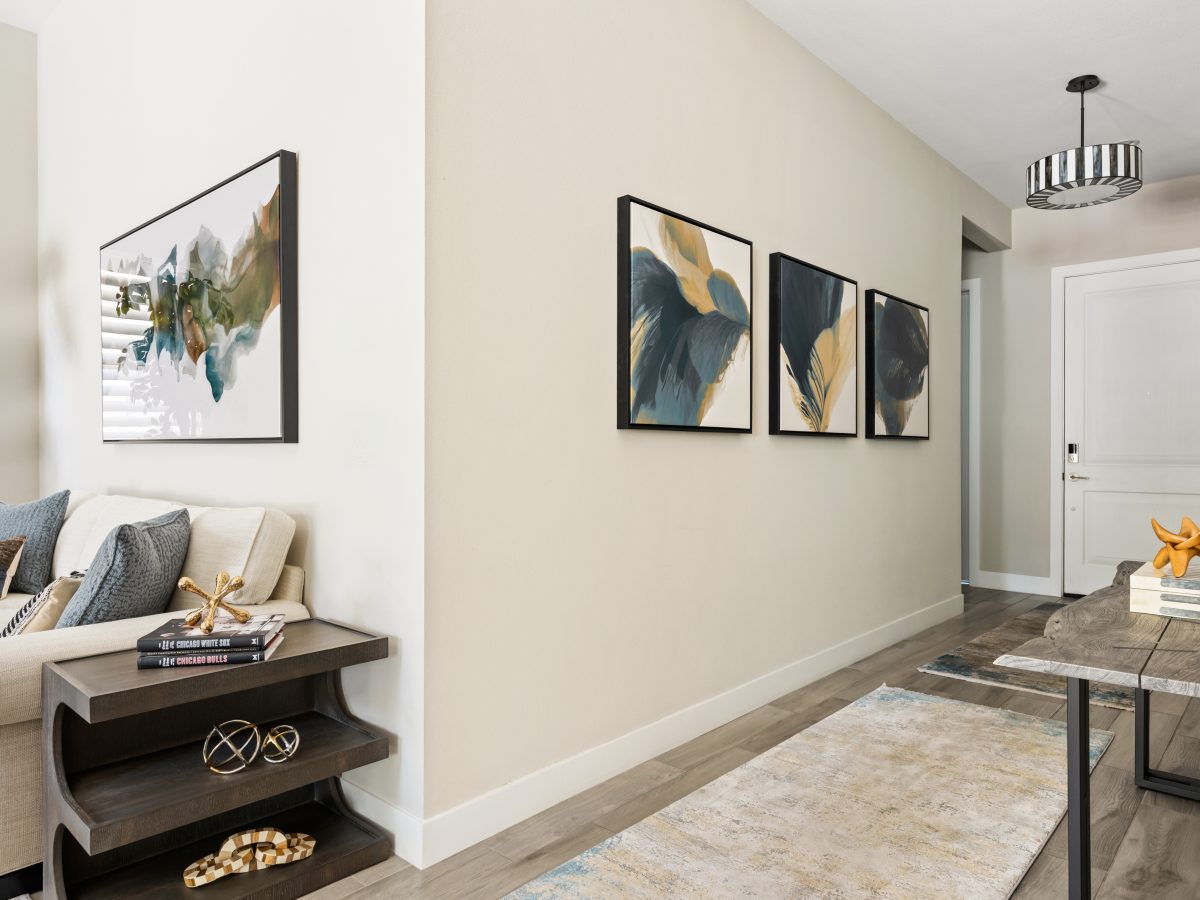 Entryway with contemporary tropical artwork, live-edge console table, and layered area rug runners, Reveal Interior Design Las Vegas