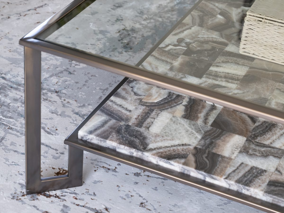Living room glass and natural stone coffee table with bronze metal frame on contemporary rug, Reveal Interior Design Las Vegas