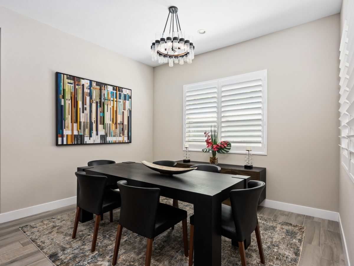Modern dining room with chunky black dining table, crystal ring chandelier, and dimensional wall art, Reveal Interior Design Las Vegas