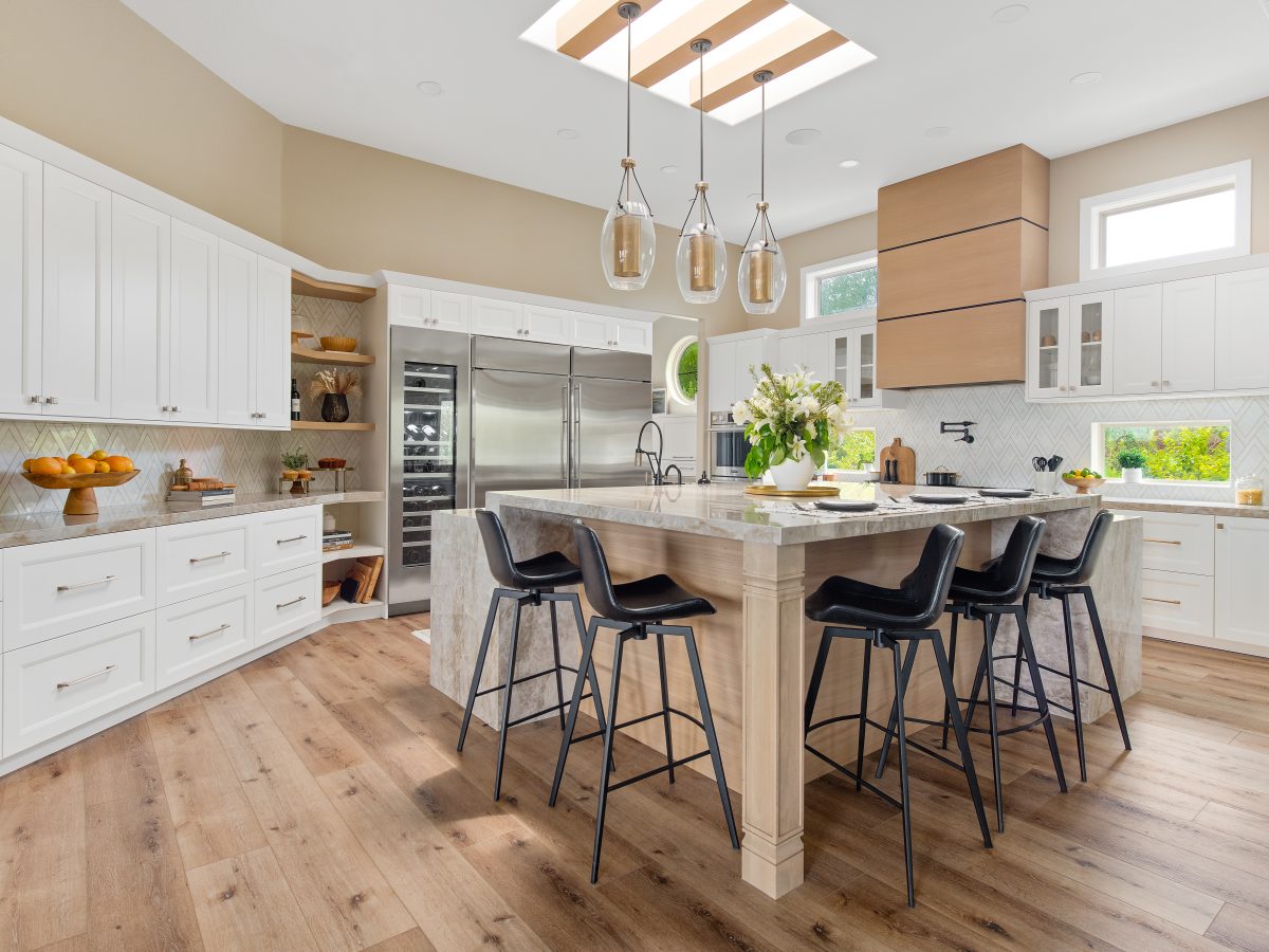 Transitional kitchen with Dekton Taj Mahal island, custom wood hood, and geometric stone backsplash, Reveal Interior Design Las Vegas