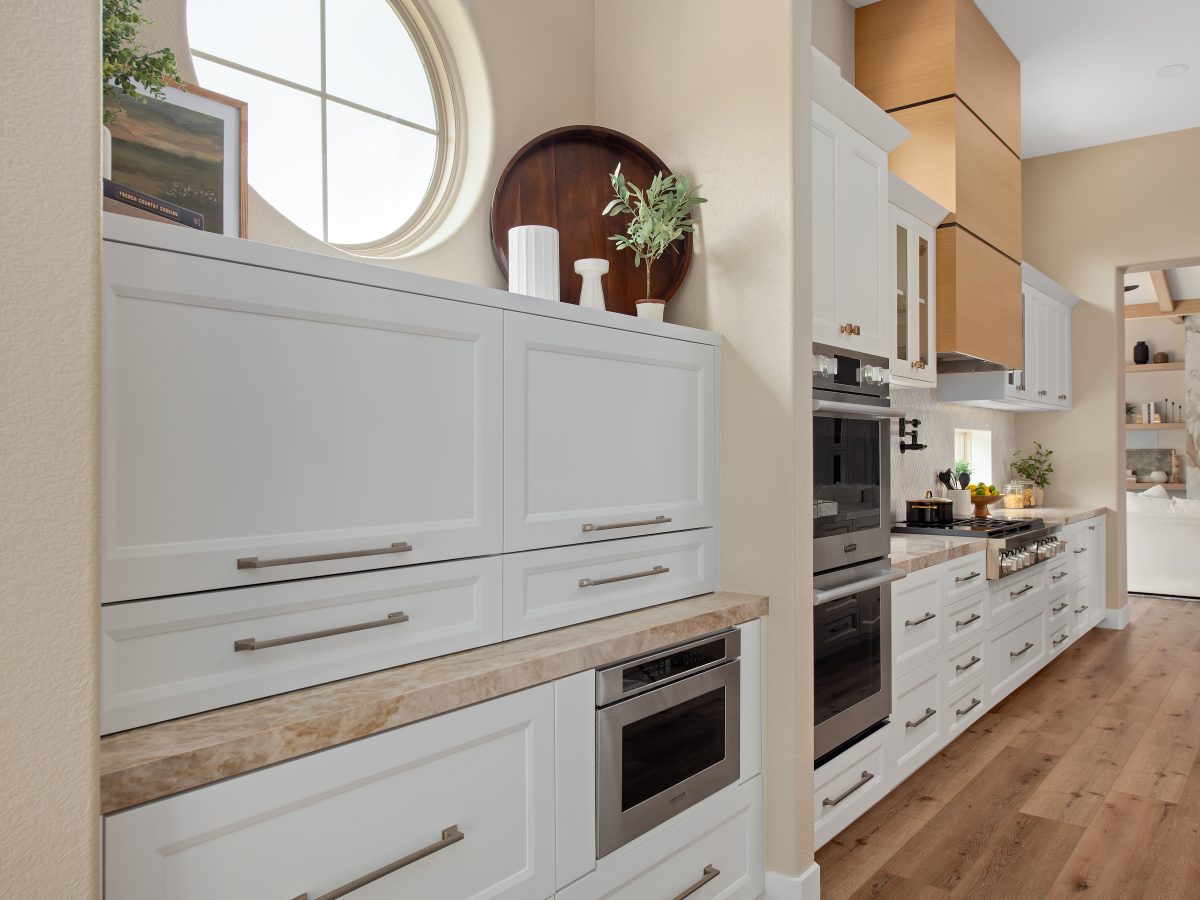 Transitional kitchen with Dekton Taj Mahal countertops, custom wood hood, and white shaker cabinetry, Reveal Interior Design Las Vegas