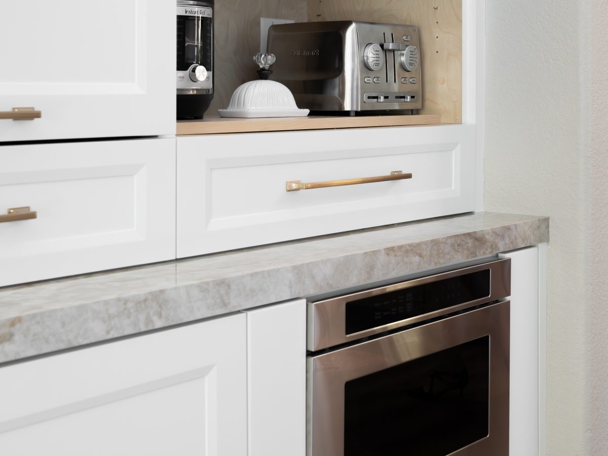 Kitchen appliance station with lift-up cabinet doors and undercounter microwave, Reveal Interior Design Las Vegas
