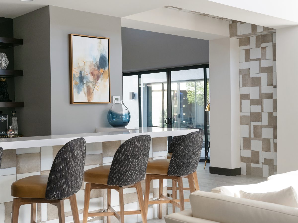 Mid-century modern bar with white quartz countertop, ceramic tile surround, and custom boucle barstools, Reveal Interior Design Las Vegas