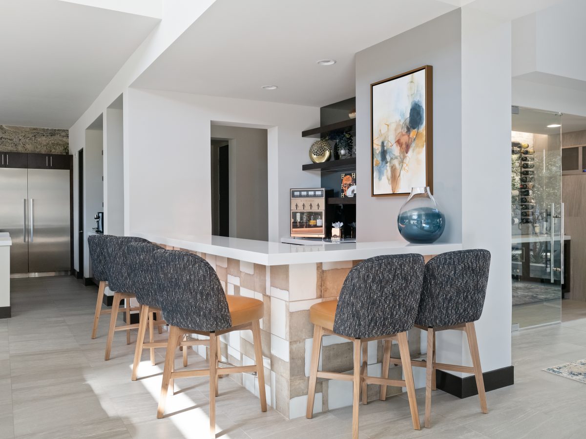 Mid-century modern bar with white quartz countertop, ceramic tile base, and custom boucle barstools, Reveal Interior Design Las Vegas