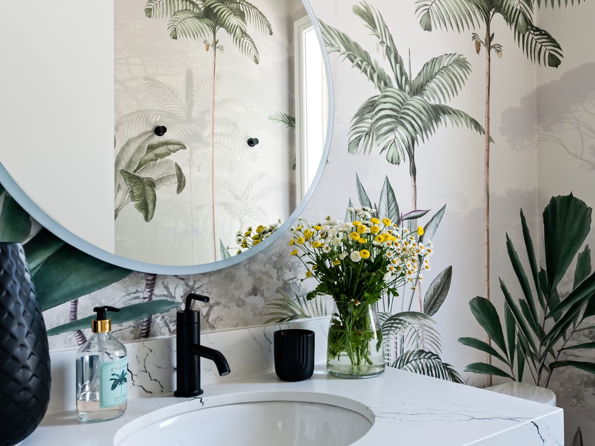 Tropical mural powder bath with white stone vanity and round mirror, Reveal Interior Design Las Vegas