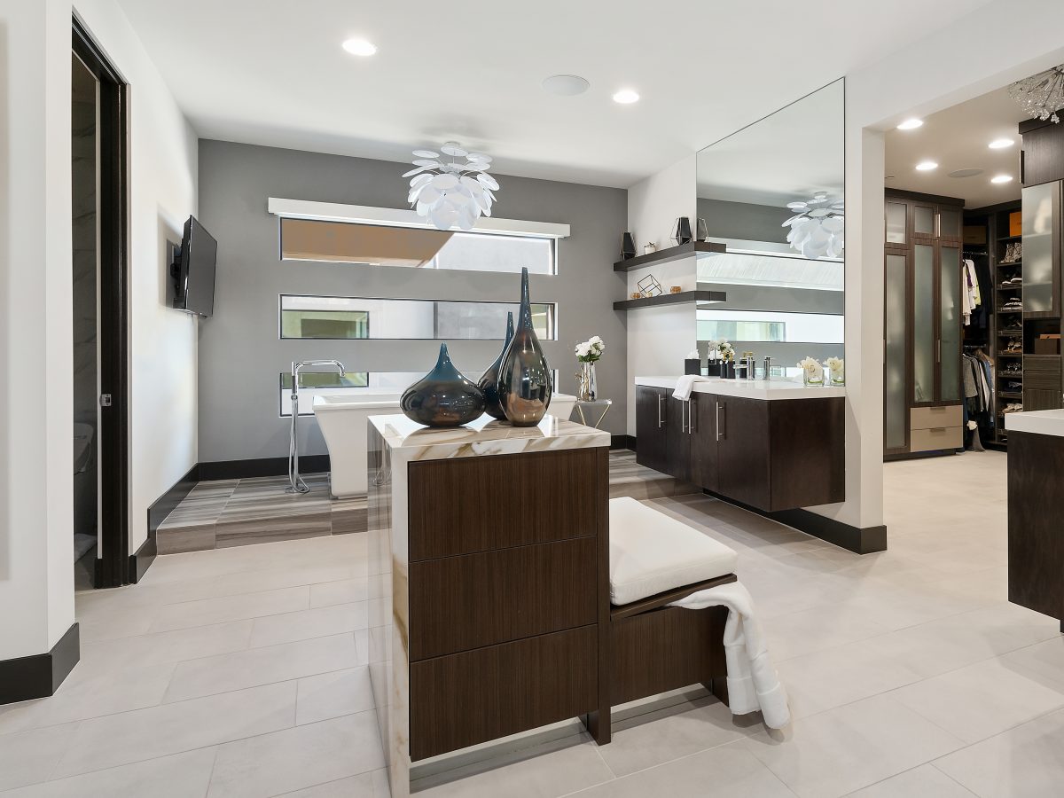Primary bathroom with floating custom island, dark stained vanities, and freestanding tub, Reveal Interior Design Las Vegas