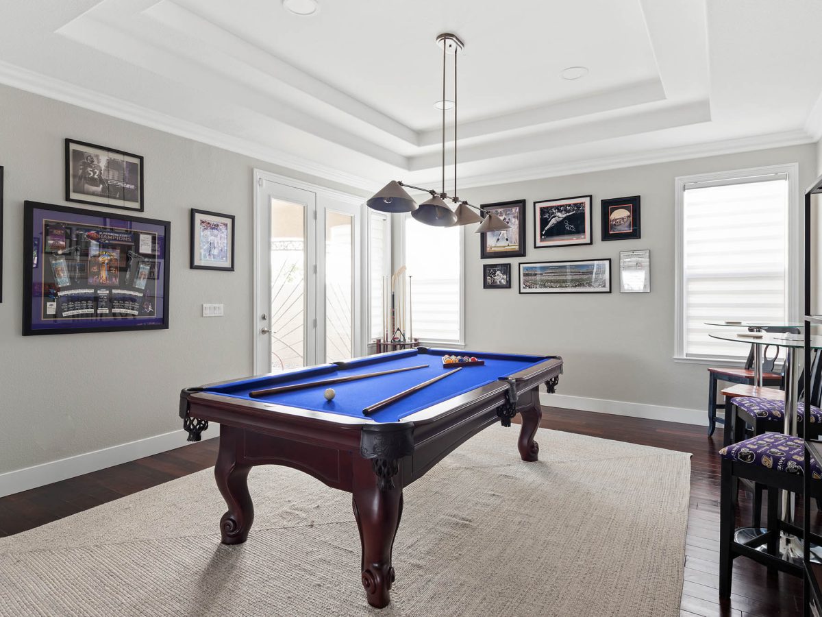 Game room with blue felt billiard table and cherry wood flooring, Reveal Interior Design Las Vegas