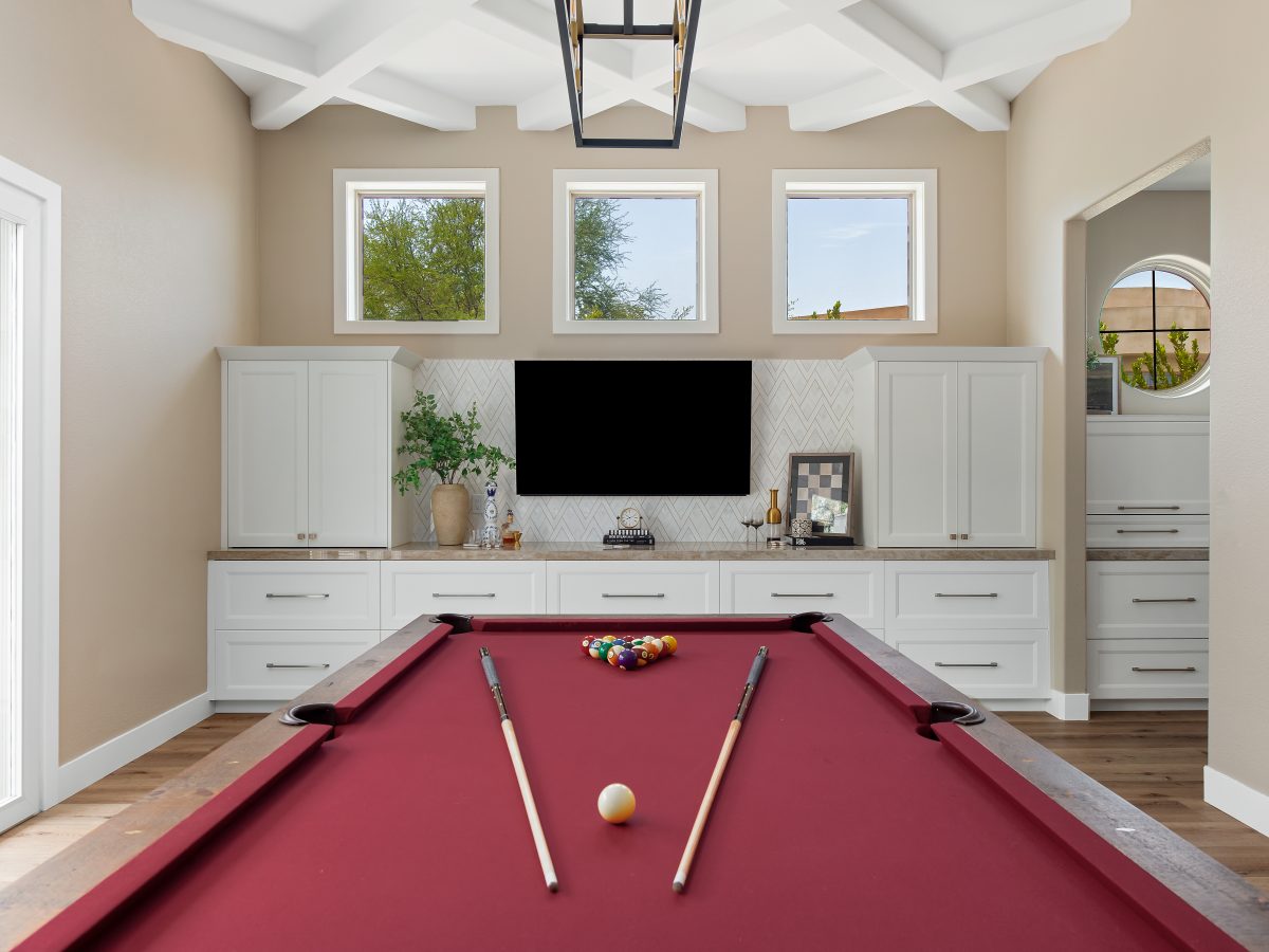Luxury game room with crimson billiard table and custom white cabinetry built-ins, Reveal Interior Design Las Vegas