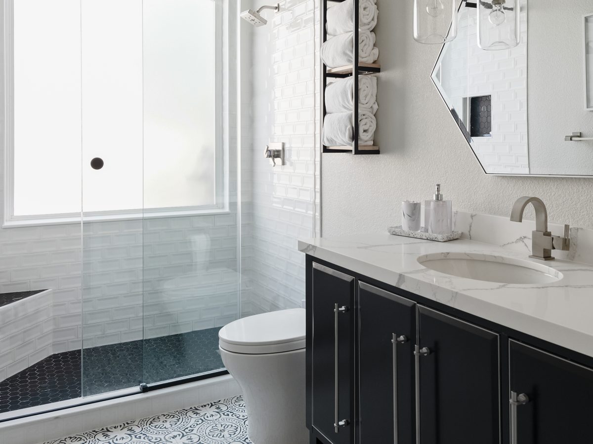 Hall bathroom with encaustic black and white floor tile, furniture-style vanity, and quartz countertop, Reveal Interior Design Las Vegas