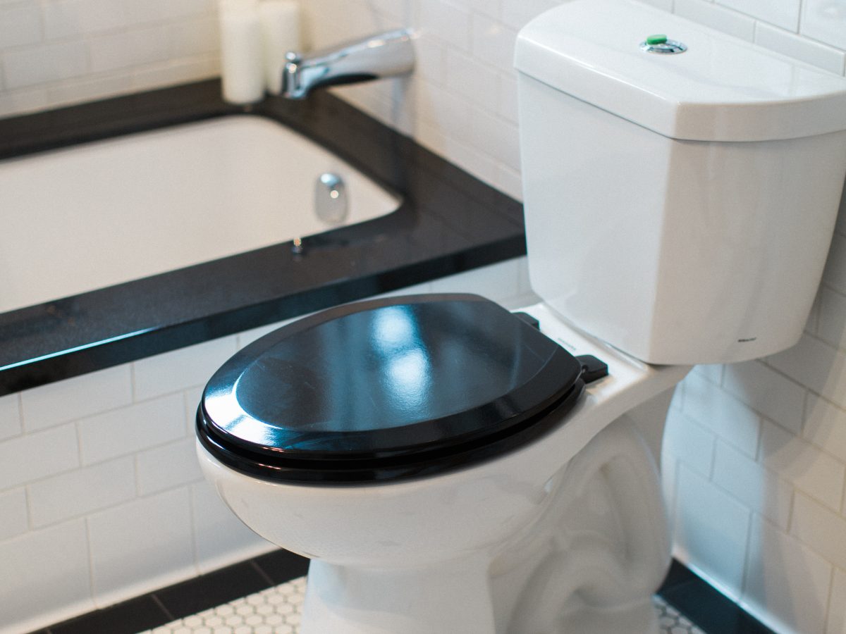 Art Deco bathroom with black-and-white hex mosaic floor and white subway tile, Reveal Interior Design Las Vegas