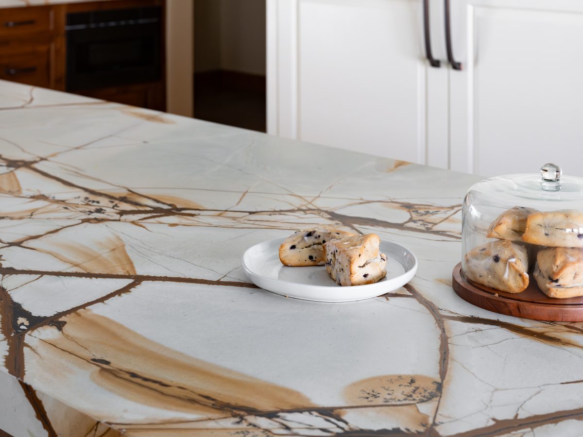 Kitchen island with blue and gold quartzite countertop and decorative legs, Reveal Interior Design Las Vegas