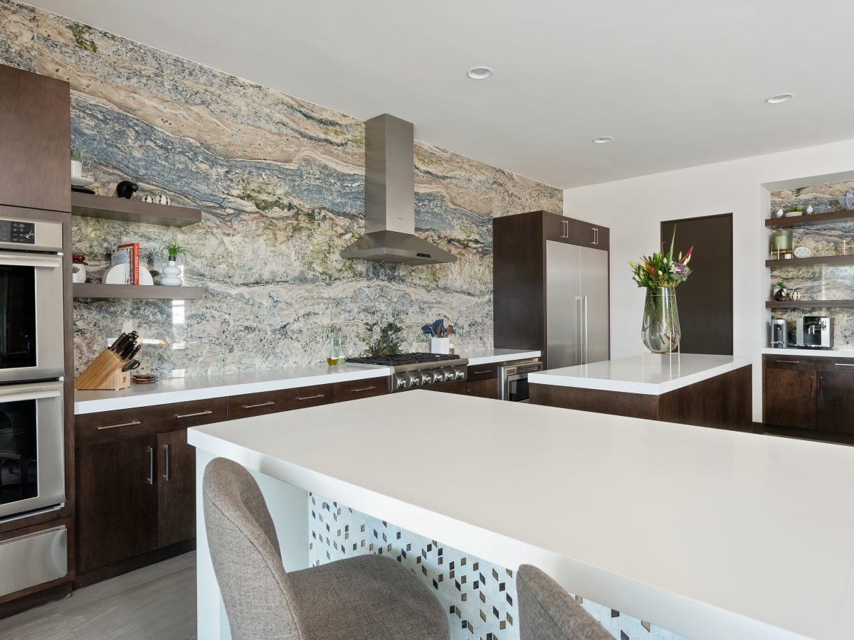 Bookmatched stone slab accent wall with white quartz countertops and dark walnut cabinetry, Reveal Interior Design Las Vegas