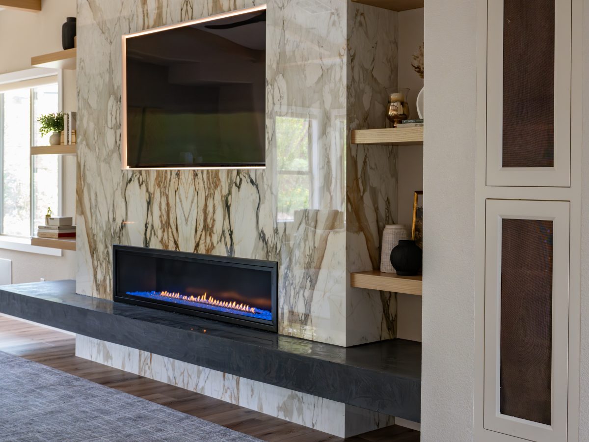 Living room with bookmatched porcelain slab fireplace surround, backlit TV, and linear fireplace, Reveal Interior Design Las Vegas