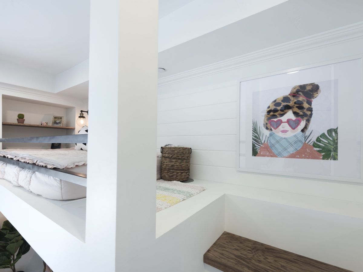 Custom three-bed bunk room with white millwork, black metal framing, and warm wood stair treads, Reveal Interior Design Las Vegas