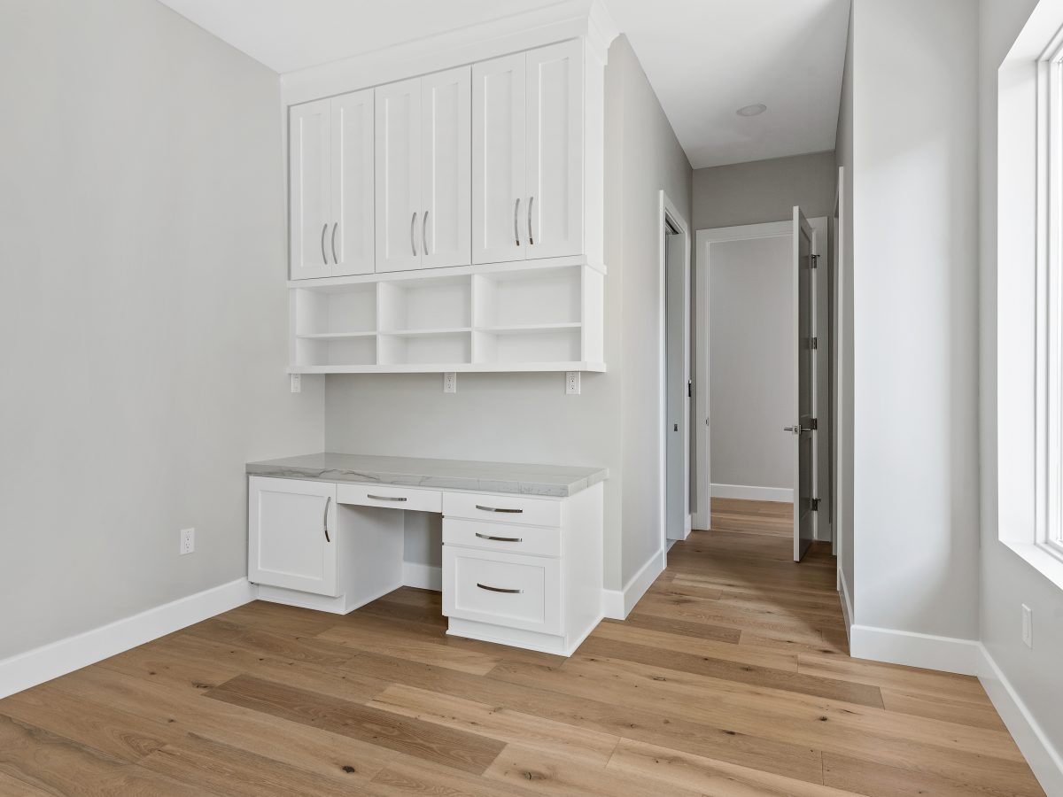 Built-in home office with white shaker cabinetry, open shelving, and stone countertops, Reveal Interior Design Las Vegas