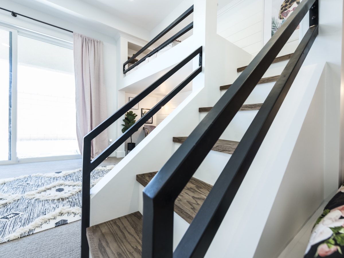 Custom bunk bed staircase with black metal railings and warm wood treads in a girls' bedroom, Reveal Interior Design Las Vegas