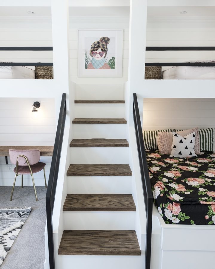 Custom queen and twin bunk bedroom with white millwork, black metal railings, and warm wood stair treads, Reveal Interior Design Las Vegas