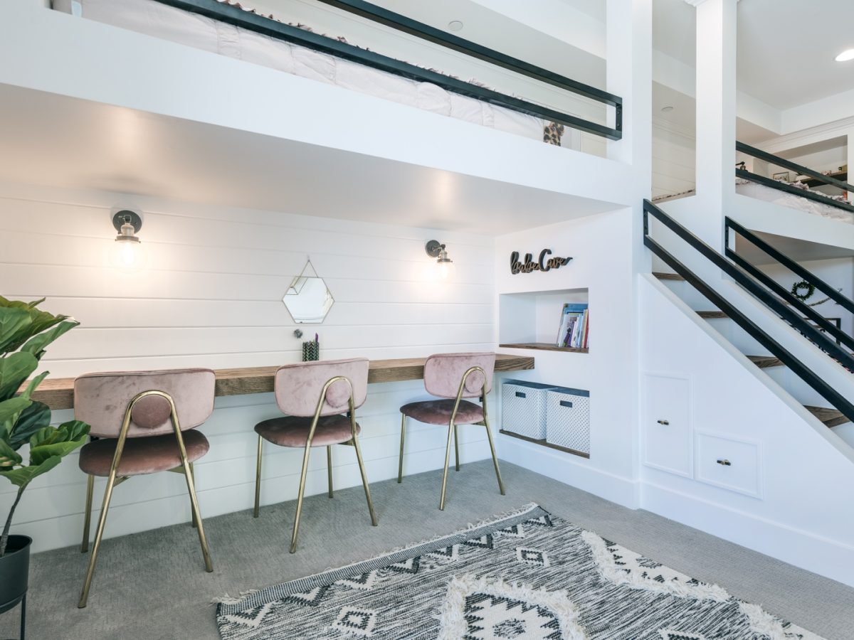 Custom three-bed girls' bunk room with built-in desk and pink velvet chairs, Reveal Interior Design Las Vegas